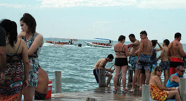 Turistas al fondo se observan las embarcaciones con turistas
